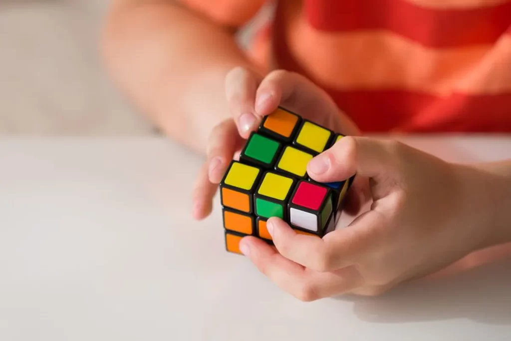 Foto de duas mãos segurando um cubo mágico 3x3x3, que estará presente no Festival ONCUBE Lindóia 2022Foto de duas mãos segurando um cubo mágico 3x3x3, que estará presente no Festival ONCUBE Lindóia 2022