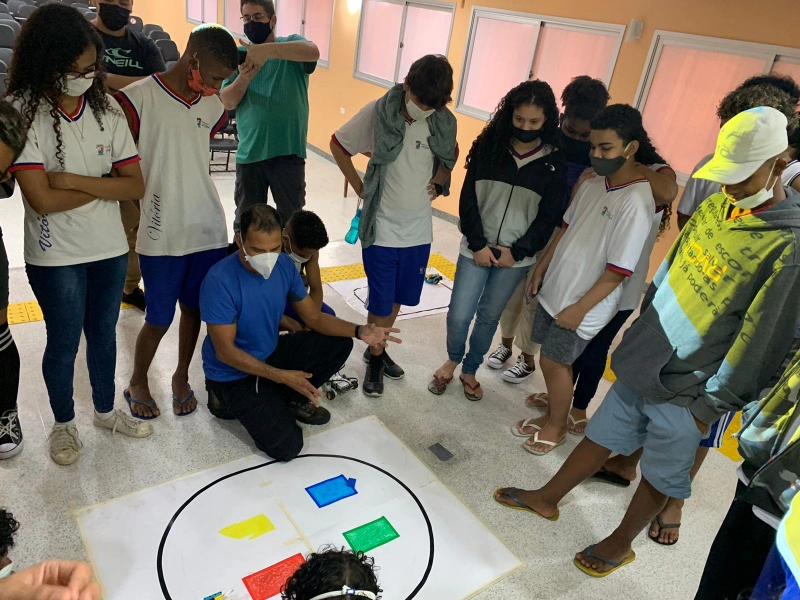 Foto dos estudantes da , da Escola Municipal de Ensino Fundamental (Emef) Alvimar Silva, em Santo Antônio (ES), observando o robô que resolve o cubo mágico, na mostra RobôMar