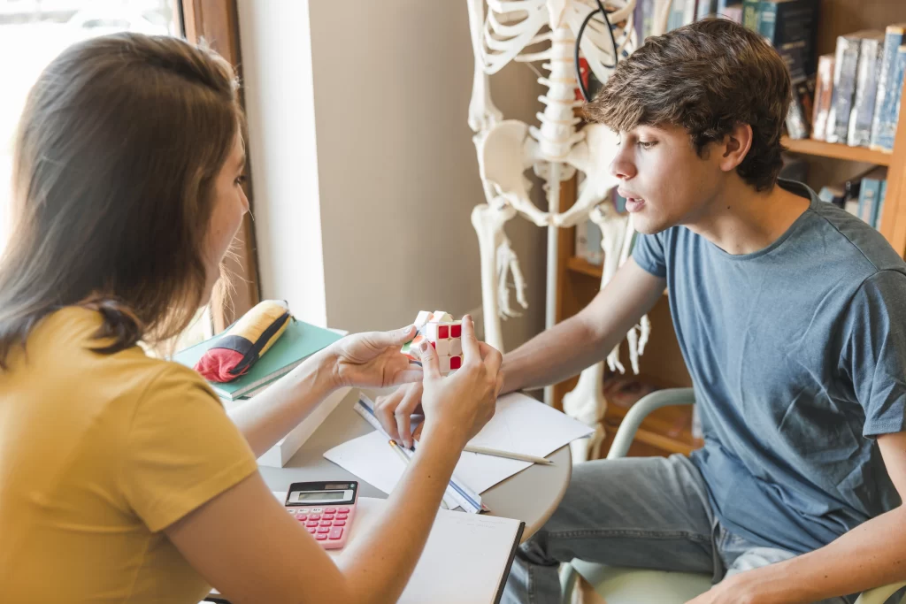 Imagem de dois adolescentes resolvendo um cubo mágico